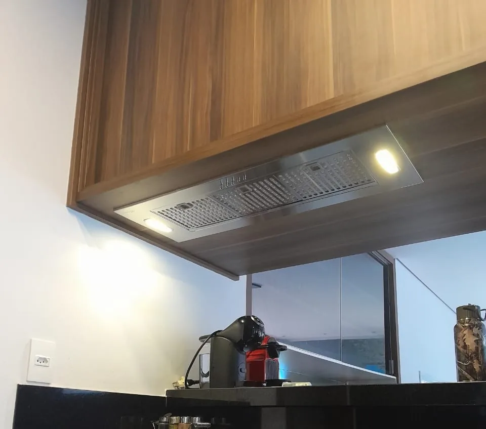 Coifa Máxima Compacta instalada sob armário, sobre o cooktop
