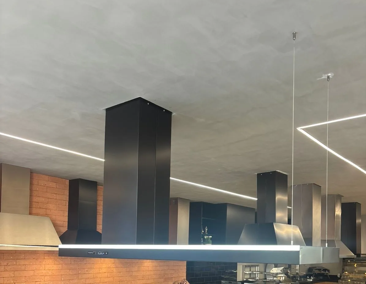 Coifa Máxima Lucent de ilha, com corpo linear iluminado e duto retangular