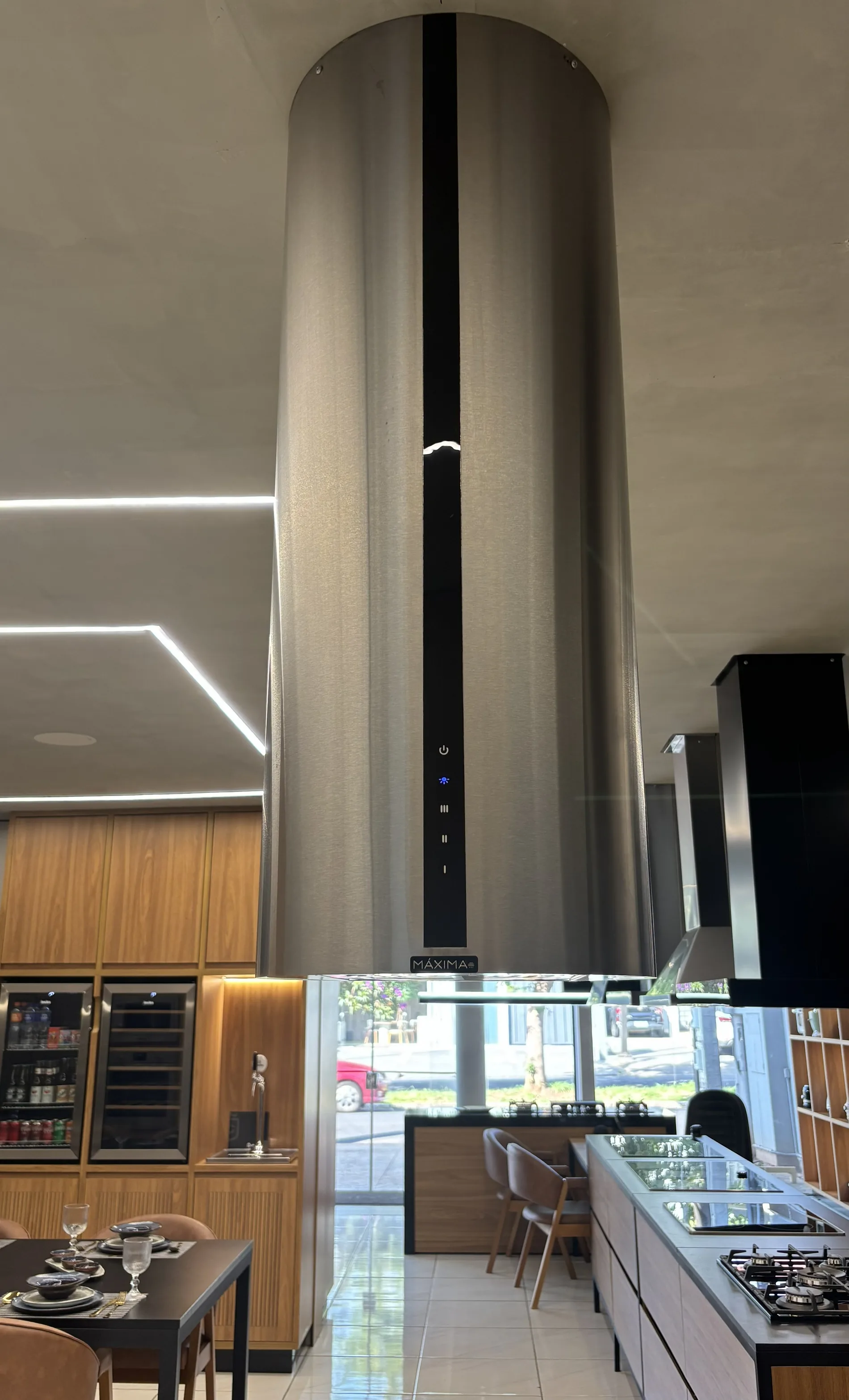 Coifa Máxima Vicenza cilíndrica de ilha, em inox, instalada no showroom